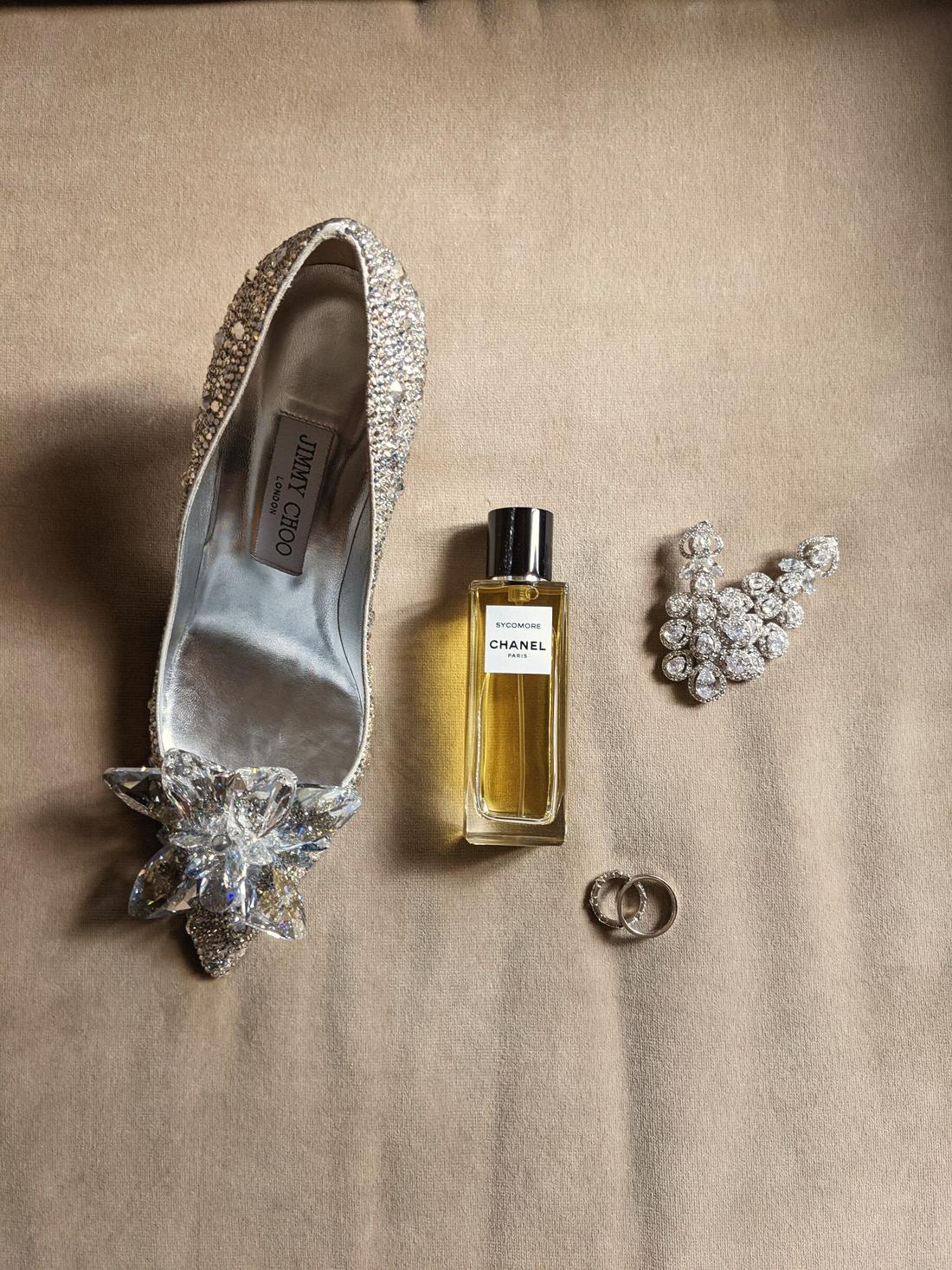 Shoes, scent and the rings laid out on linen