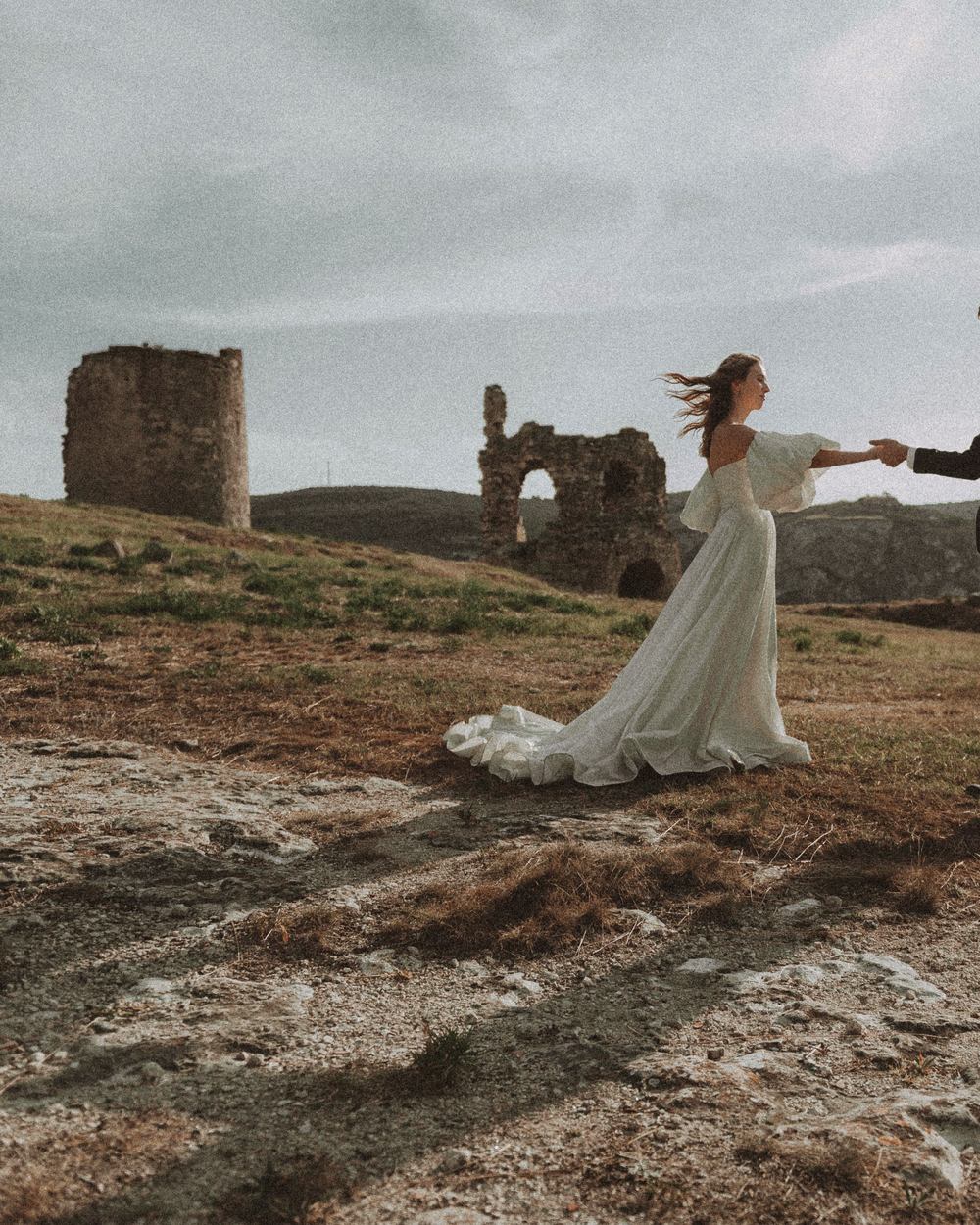 Open country and a ruined tower under a wide dusk sky