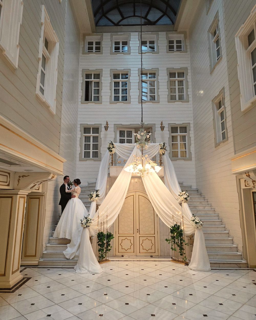 A couple under drapes in a palace courtyard